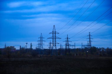 Yüksek voltajlı hatlar alacakaranlıkta büyük bir santrale gidiyor.