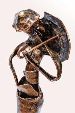 Şemsiyeli bir kadın şeklinde dövülmüş metal bir heykel.