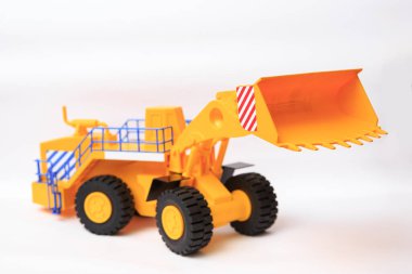 Beyaz arkaplandaki sarı tek kovalı yükleyicinin ölçekli modeli