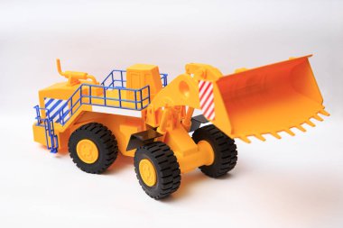 Beyaz arkaplandaki sarı tek kovalı yükleyicinin ölçekli modeli