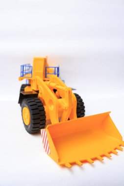 Beyaz arkaplandaki sarı tek kovalı yükleyicinin ölçekli modeli