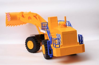 Beyaz arkaplandaki sarı tek kovalı yükleyicinin ölçekli modeli