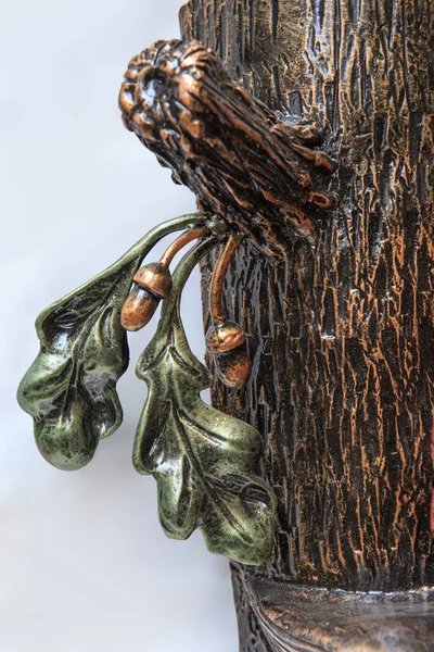 Figurine of an oak tree branch with acorns of a tree. The tree is made of metal