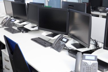 Ofiste bilgisayar monitörü ve telefonu olan, insanların olmadığı bir yer..