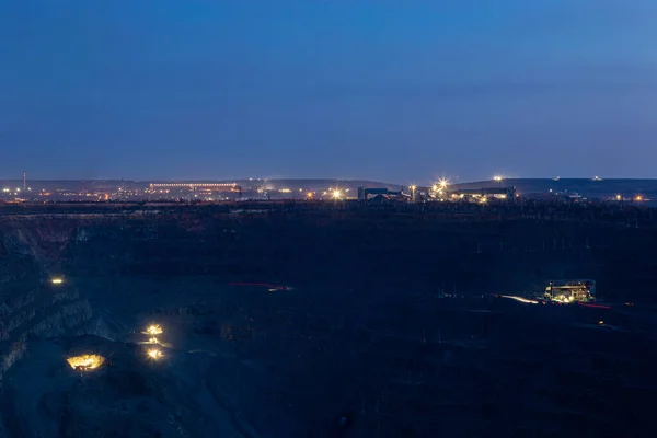 The process of iron ore mining in the quarry at night. Round-the-clock production process