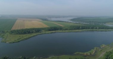 Büyük geniş nehir bozkırlarda ormanlık bankalar ve tarım arazileri arasında akar. İnsansız hava aracı görüntüleri.