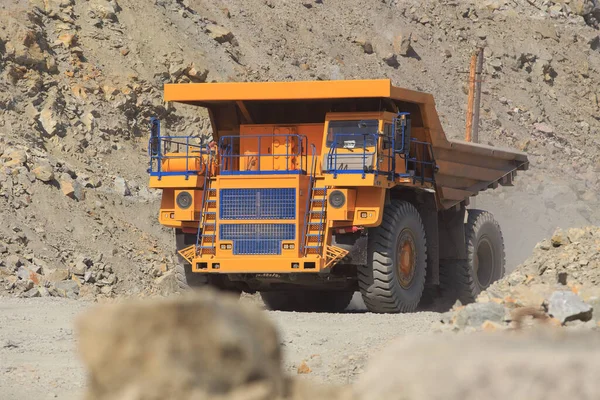 晴れた日に道路上の大規模な黄色の鉱山ダンプトラック 採石場における岩塊の運搬用の大型装置 — ストック写真