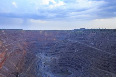 Açık çukur demir cevheri çıkarma, hammaddelerin metalürji için hazırlanması. Taş ocağında ağır ekipman panoraması.