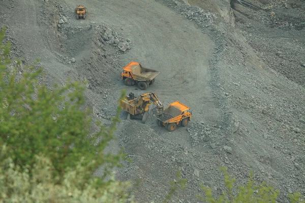 採石場のダンプトラックに鉱石を積み込む 大規模なショベルや大型トラックを使用した露天掘り採掘のプロセス — ストック写真