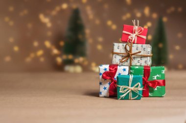 Yılbaşı ışıkları ve ağaçlarının arka planına karşı hediyeler dağı..