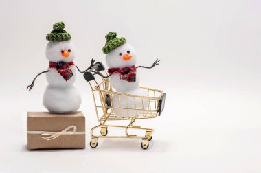 Beyaz arka plandaki kardan adamlar yeni yıl için alışveriş yapıyorlar.