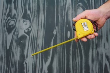 Gri ahşap arkaplandaki inşaat bandı.