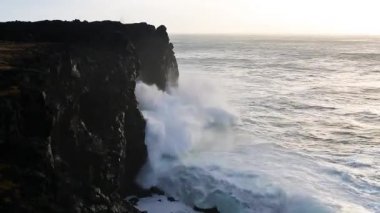İzlanda'daki siyah kayalar üzerinde kırma dalgalar