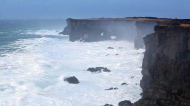 İzlanda'daki siyah kayalar üzerinde kırma dalgalar
