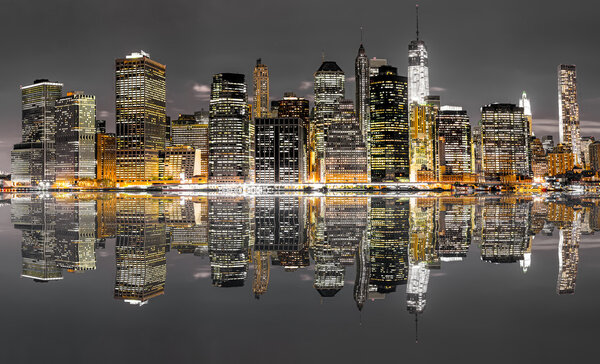 Panoramic night view of New York City with reflection in water