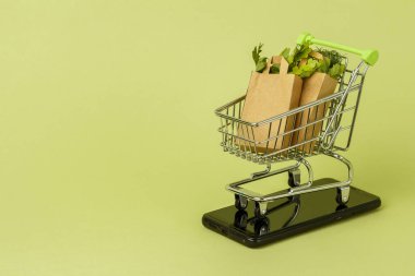 İçinde taze yeşil salata olan kağıt alışveriş torbaları, tramvay. Kentsel Çevre Gıda dağıtım mobil uygulama kavramı. Servis uygulaması.