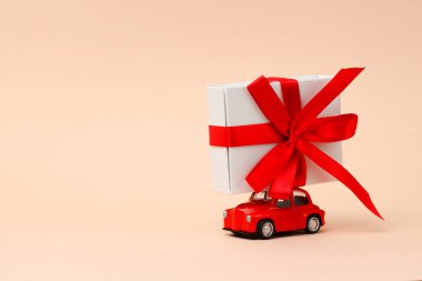 Sevgililer günü, yeni yıl, küçük kırmızı eski oyuncak araba çatıda büyük bir hediye ve pembe arka plan. Dünya Kadınlar Günü 'nde Noel için hediyeler getirdim. Satış kavramı. Boşluğu kopyala
