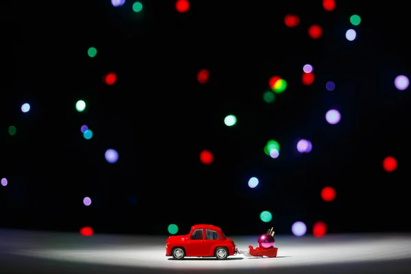 イルクーツク ロシア 2020年11月28日 クリスマスの前夜にクリスマスボールでそりを運ぶクリスマスの赤い車 ハッピーニューイヤーカードのコンセプト — ストック写真