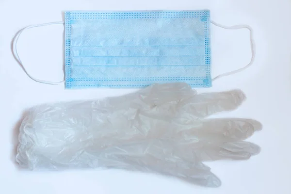 Máscara médica y guantes de goma sobre fondo blanco. Concepto de necesidad, nueva realidad, protección antivirus, covid-19 — Foto de Stock