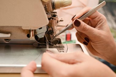 Terzi kadın dikiş makinesinde çalışıyor. Tek bir girişimci tarafından düzenin sağlanması. Küçük işletme kavramı