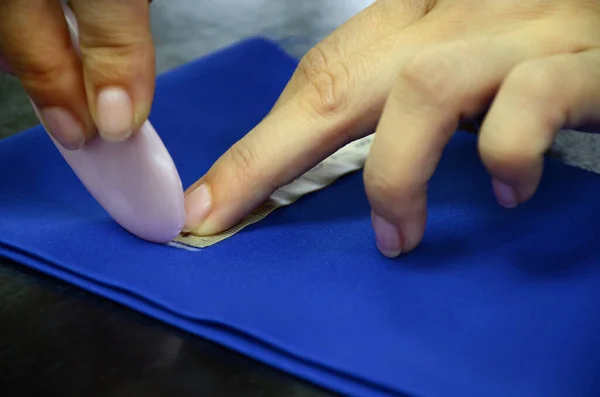Швейный мастер делает ремесло из ткани. Резка с меткой мыла на голубой ткани. Обрезка ткани для шитья. Концепция малого бизнеса. — стоковое фото