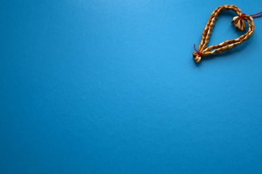 Mavi arka planda, kırmızı iplikli samandan yapılmış bir kalp. Tatil konsepti, sevgililer günü, düğün, kadınlar günü, doğum günü. Boşluğu kopyala.