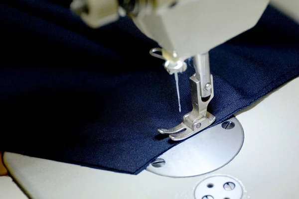 Näht Kleidung Aus Dunkelblauem Stoff Auf Einer Weißen Nähmaschine Konzept — Stockfoto