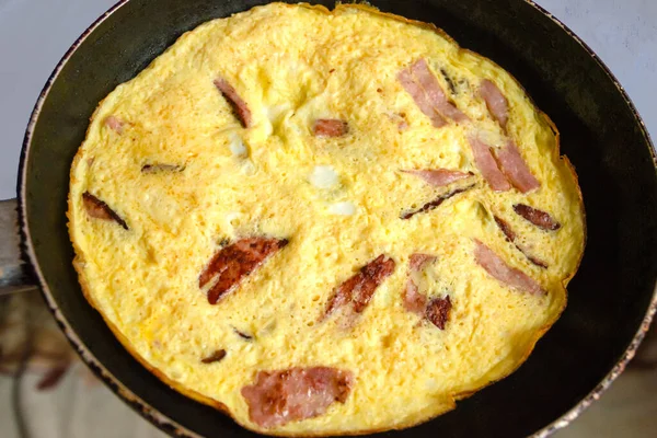 Sosisli yumurtalı omlet. Kızartma tavasında kızarmış kahvaltı.