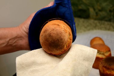 Bir kadın, paskalya pastasını bir hilebazın kalıbından, beyaz bir havludan çıkarır. Ev konforu kavramı.