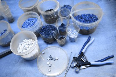 Masanın üzerindeki plastik kaplarda farklı renklerde. Klasik mavi tonda fotoğraf. Meme uçlarının ve cımbızların yanında. Seçici odak.