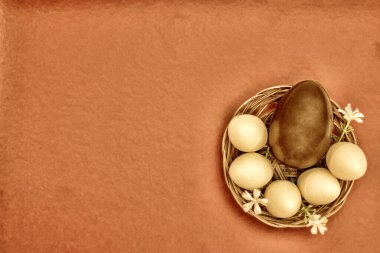 Çiçekli sepetteki çikolatalı yumurtalar düzdü. Paskalya yumurtaları, süt ve koyu çikolata, ton siyah altın. Paskalya bahar tatili, yakın plan, kopyalama alanı.