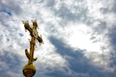 Gökyüzünün arka planında gri bulutlarla çapraz yap. Altın ortodoks çapraz çekimi. Din kavramı, yatay fotoğraf.