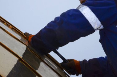 Ortodoks kilisesinin yaldızlı kubbesini birleştiriyorum. Eldiven ustası, plastik bir çekiçle kubbenin parçalarını topluyor..