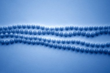 Aydınlık arkaplanda sıralanmış boncuklar klasik mavi renk, moda 2020. 8 Mart için hediye, Kadınlar Günü, Düğün, Sevgililer Günü, Doğum günü. Seçici odak.