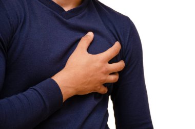 Mavi kazaklı bir adam kalp bölgesinde elini tutuyordu. Keskin ağrı, izole edilmiş, yatay fotoğraf.