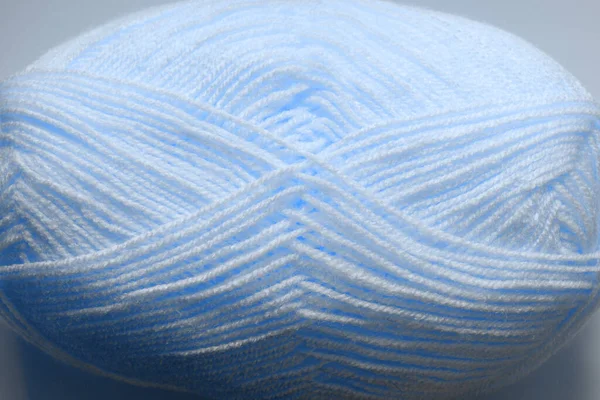 Light beige woolen threads in a skein for knitting close-up and for the background. Photo toned in a classic blue color. Gift for Women\'s Day or Mother\'s Day