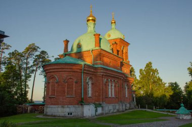 Valaam Manastırı 'nın Diriliş Tasviri. Kırmızı tuğla bina, güneşli bir yaz gününde ormanın ortasında inziva yeri..