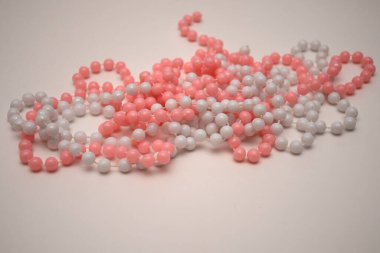 Açık arkaplanda pembe ve beyaz boncuklar. 8 Mart için hediye, Kadınlar Günü, Düğün, Sevgililer Günü, Doğum günü. Seçici odak.