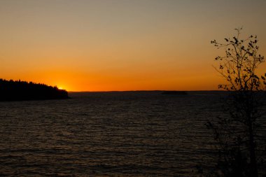Gölün üzerinde güzel bir yaz günbatımı. Doğanın yatay fotoğrafı