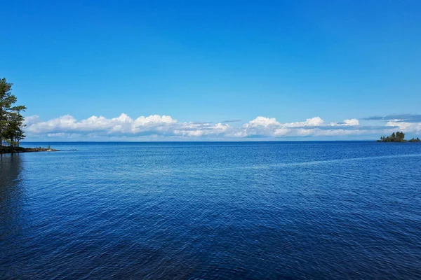 Φωτεινός Μπλε Ουρανός Λευκά Σύννεφα Πάνω Από Μια Ήρεμη Λίμνη — Φωτογραφία Αρχείου