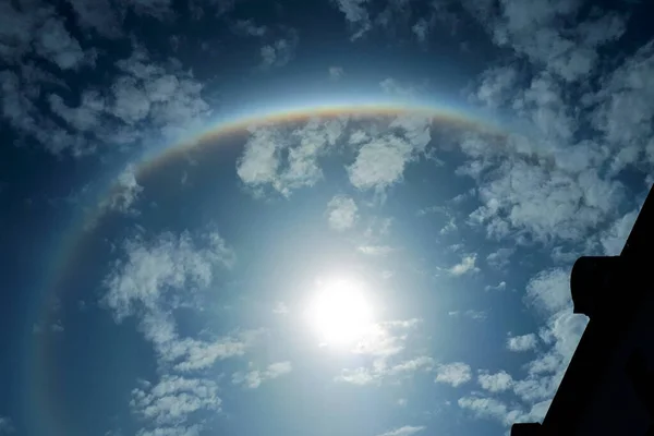 白い雲と青空に虹のハロー 中央の太陽と魔法の自然の虹の効果 — ストック写真