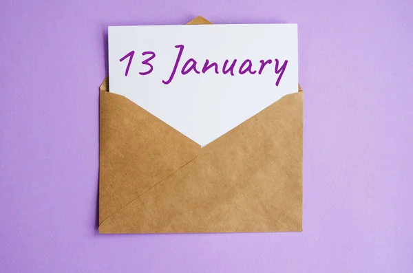 Sobre Kraft con una hoja de papel blanco y la inscripción del 13 de enero sobre fondo lila. Calendario de correspondencia y concepto de fecha memorable — Foto de Stock