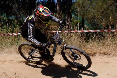 Bisikletçi çalılıklardaki bir yarışta viraj yapıyor.