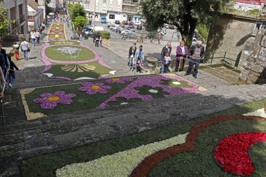 Çiçekli halı yığını sokağı süslüyor.