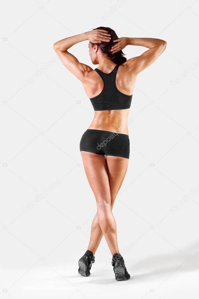 muscular athletic young slim woman  on a light background. fitne