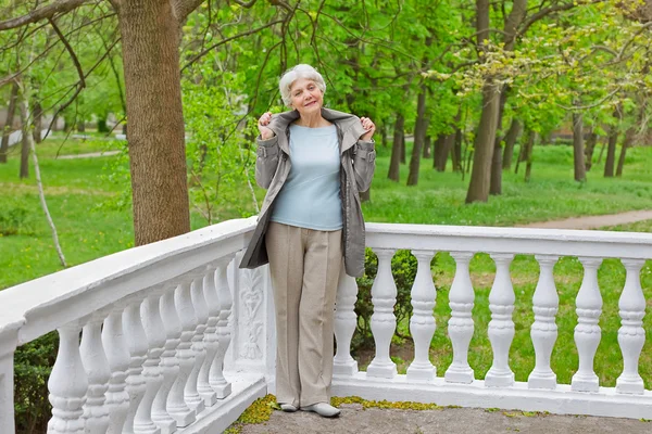 Sød ældre kvinde senior på den smukke hvide verandah i - Stock-foto