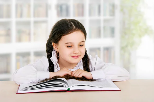 Feliz criança menina lê livro interior — Fotografia de Stock