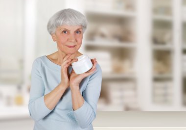yüzünü yüz cilt bakımı kozmetik krem uygulayarak çekici yaşlı kadın
