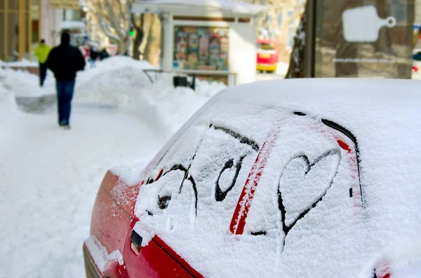 Weißer Schnee mit ertrinkender Herzform. Herz mit dem Auto auf einer Straße in der Stadt in den Schnee gezogen. Hintergrund — Stockfoto