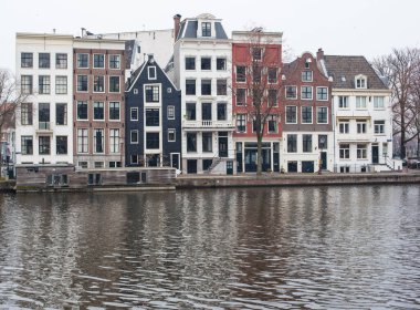 Amsterdam kanal evleri ve sudaki yansımaları